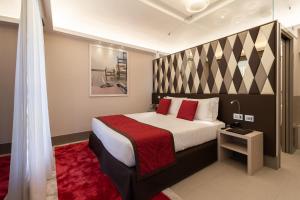 1 dormitorio con 1 cama grande con almohadas rojas en Harry's Bar Trevi Hotel & Restaurant, en Roma