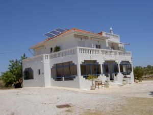 uma grande casa branca com um painel solar no telhado em Quartos Com Boas Vistas em Ribeira da Gafa