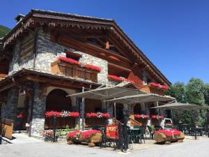 a building with tables and umbrellas in front of it at B&B San Sebastiano in Vernante