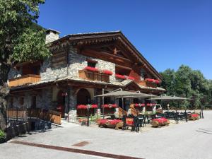 a building with tables and chairs in front of it at B&B San Sebastiano in Vernante