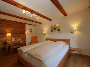 a bedroom with a large bed and a desk at Hotel Alpenblick in Zeneggen