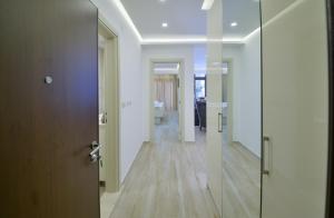 un corridoio con pareti bianche, pavimenti in legno e una porta di Brand New Apartments a Sveti Stefan