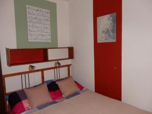 1 dormitorio con 1 cama y puerta roja en Orgona Vendégház, en Velence