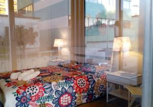 1 dormitorio con cama, mesa y ventana en Famille au Cœur de Lisbonne, en Lisboa