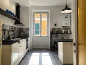 kuchnia z białymi szafkami i oknem w obiekcie GLAM 50 - Exlusive Penthouse in the Heart of Rome w Rzymie