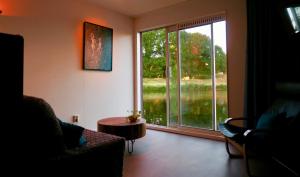 a living room with a large window and a table at B&B De Leeuw in Zwolle