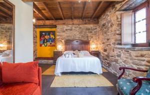 a room with a bed and a stone wall at Casa do Morcego in Valdoviño