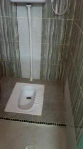 a bathroom with a toilet in the floor of a stall at Seri Pengkalan Holiday House in Bachok +40 photos