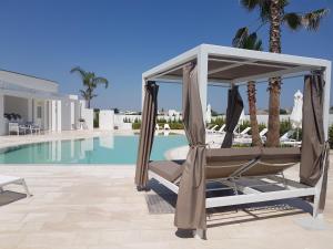 a hammock by the pool at a resort at I MESTRI Holiday Homes in Uggiano la Chiesa