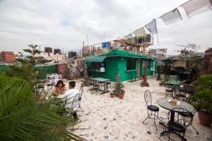 two people sitting in a patio with a building at Hotel Family Home in Kathmandu