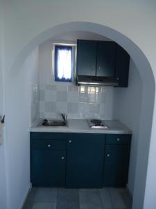 a kitchen with blue cabinets and a sink at Colosseo Star in Agios Prokopios