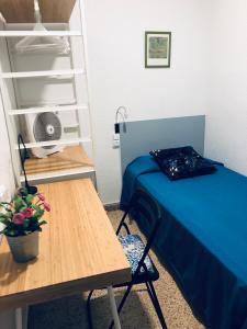 Kleines Zimmer mit einem Bett und einem Tisch in der Unterkunft Hostal Carlos III in El Prat de Llobregat