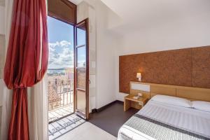 1 dormitorio con cama y ventana grande en Grande Albergo Alfeo en Siracusa