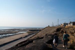 twee mensen lopen op de rotsen bij het strand bij The Highfield Private Hotel in Blackpool