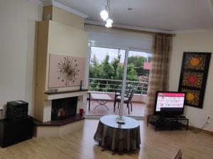a living room with a fireplace and a television at House,1000m from the beach in Lagonissi