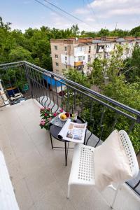 - un balcon avec une table et des chaises dans l'établissement New 2 bedrooms apartment in the city center!, à Mykolaïv