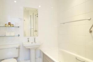 a white bathroom with a sink and a toilet at The Royal Hotel in Ventnor