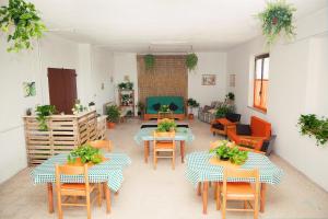 ein Wohnzimmer mit Tischen, Stühlen und einem Sofa in der Unterkunft LE PIUME B&B in Cupramontana