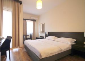 1 dormitorio con cama, escritorio y ventana en Lucic Rooms & Suites, en Budva