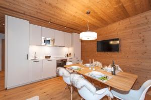 a kitchen and dining room with a wooden ceiling at Alpin Chalet Schröcken in Schröcken