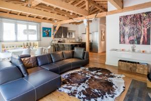 ein Wohnzimmer mit einem Sofa und einer Küche in der Unterkunft Penthouse le Bartavel - Chamonix All Year in Chamonix-Mont-Blanc