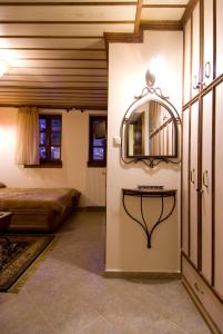 - une chambre avec un lit et un miroir mural dans l'établissement Kato Machalas, à Dikoryfo
