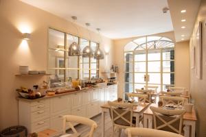 ルッカにあるB&B Residenza Di Via Fontanaの白いキャビネットと椅子、テーブル付きのキッチンが備わります。