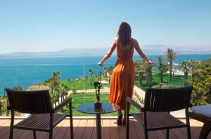 a woman standing on a balcony looking out at the ocean at ON'LIVE HOTEL in Çeşme