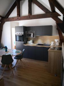 a kitchen with black cabinets and a table with chairs at Appartement Rue Haute des Bains in Le Croisic