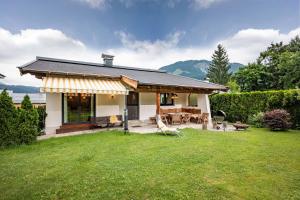 een huis met een patio met een tafel en stoelen bij Exclusive Appartement Chalet in Sankt Johann in Tirol