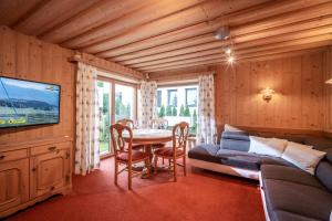 a living room with a table and a couch and a television at Exclusive Appartement Chalet in Sankt Johann in Tirol