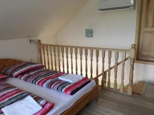 una cama con almohadas a rayas en una habitación en Napfény Apartman en Sárospatak