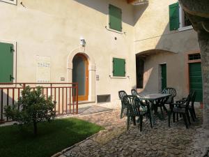 eine Terrasse mit einem Tisch und Stühlen neben einem Gebäude in der Unterkunft casa antico borgo in Assenza di Brenzone