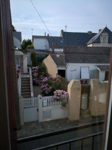 Appartement Rue Haute des Bains في لو كروازيك: اطلاله على بلكونه مع سياج ابيض وزهور