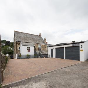 a detached house with a garage and a driveway at Cliftons Guest House in Truro
