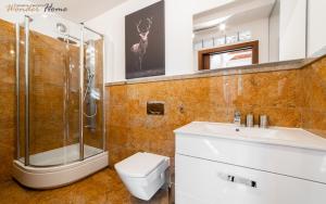 ein Badezimmer mit Dusche, Toilette und Waschbecken in der Unterkunft Wonder Home - Apartamenty blisko stoku, centrum i aquparku in Karpacz + 19 Fotos