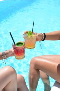 two women sitting in the swimming pool holding drinks at Casa Grande Hotel in Platis Yialos Mykonos