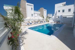 a swimming pool with chairs next to a building at Fig Tree Bay Residences Lantiana Villa 1 in Protaras