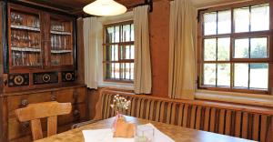 a dining room with a table and two windows at Ferienhaus Wella in Holzgau