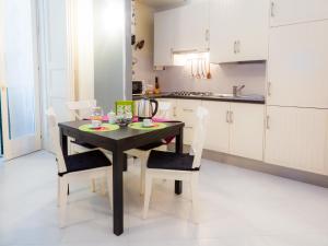 une cuisine avec une table noire et des chaises blanches dans l'établissement Napolincentro Loft, à Naples