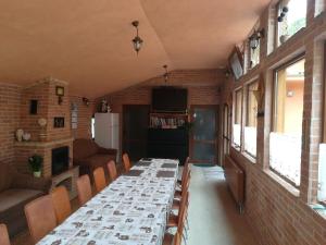 a dining room with a long table and chairs at Pensiunea Colt Alb in Băile Homorod