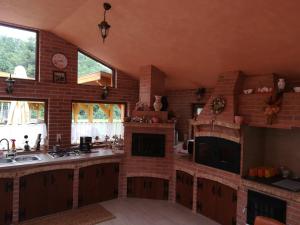 a large kitchen with a brick wall at Pensiunea Colt Alb in Băile Homorod