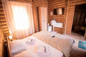 1 dormitorio con 1 cama en una cabaña de madera en Частный дом Elisa Sarkau, en Lesnói