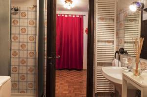 baño con cortina de ducha roja y lavamanos en AUGUSTA casa vacanza, en La Thuile