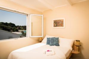 ein Schlafzimmer mit einem Bett und einem großen Fenster in der Unterkunft La Villa-Silba in Silba