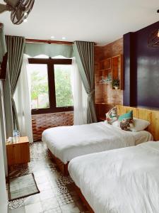 a bedroom with two beds and a window at Gallery homestay in Quy Nhon