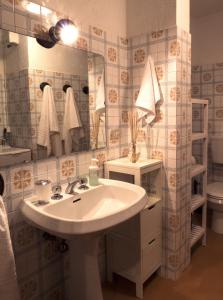 uma casa de banho com um lavatório, um WC e um espelho. em AUGUSTA casa vacanza em La Thuile