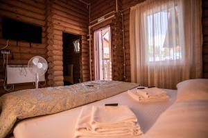 um quarto com uma cama e uma janela num chalé de madeira em Частный дом Elisa Sarkau em Lesnoy