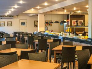 um restaurante com mesas e cadeiras e uma cozinha em Rio das Pedras Thermas Hotel em Caldas Novas