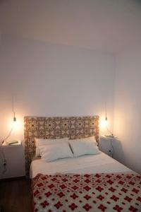 a bedroom with a bed with a red and white blanket at Portolà, 1 apartament in Balaguer